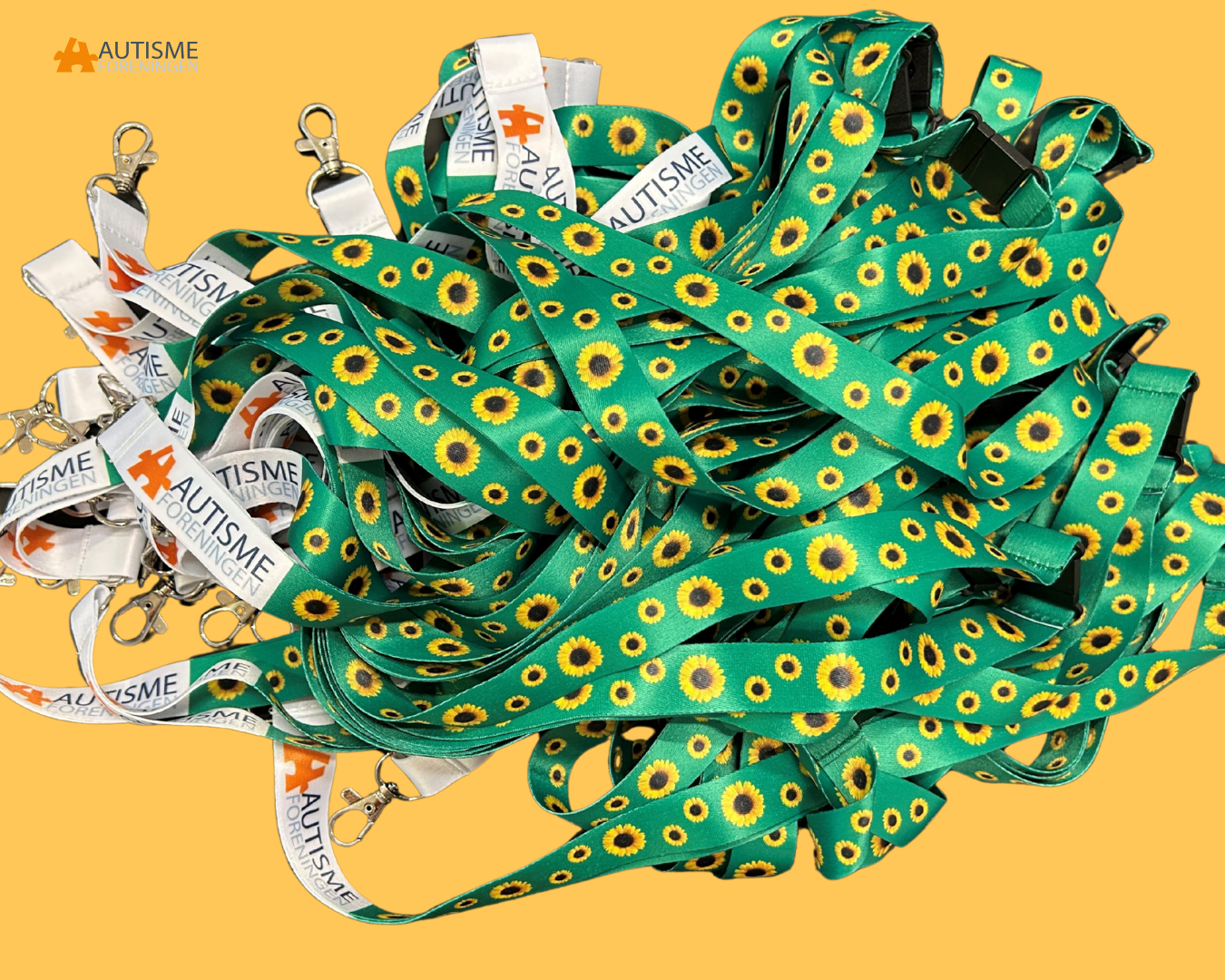 Adskillige Solsikkesnore med Autismeforeningens mærke på ligger i en stor bunke.
