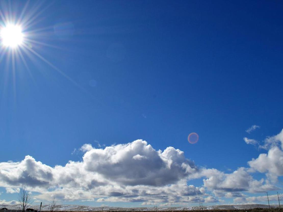 blå sommerhimmel med få skyer og stærk sol