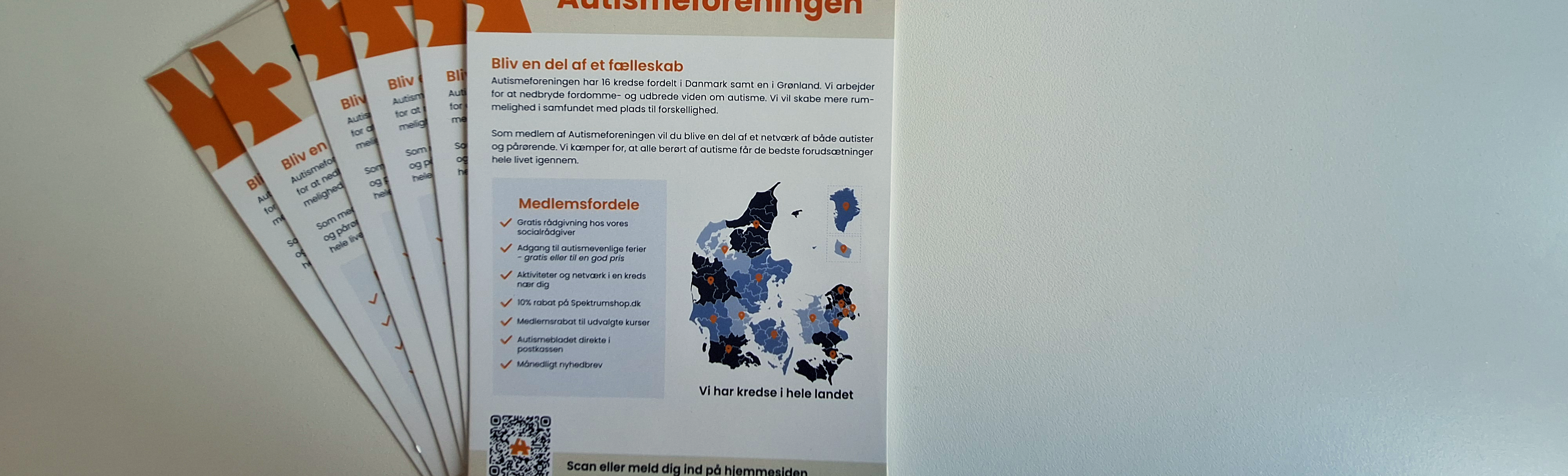 En håndfuld pjecer fra Autismeforeningen ligger spredt i vifte