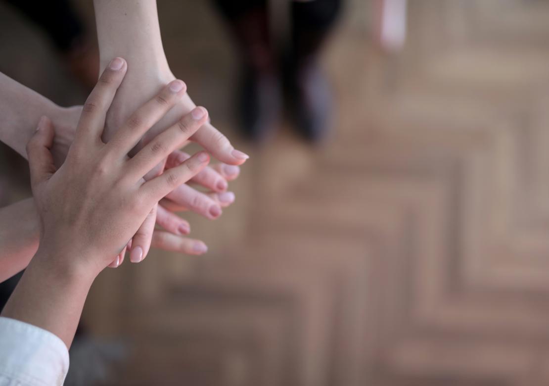 Flere mennesker, der giver hinanden håndslag på en aftale. Fokus er på hænderne.