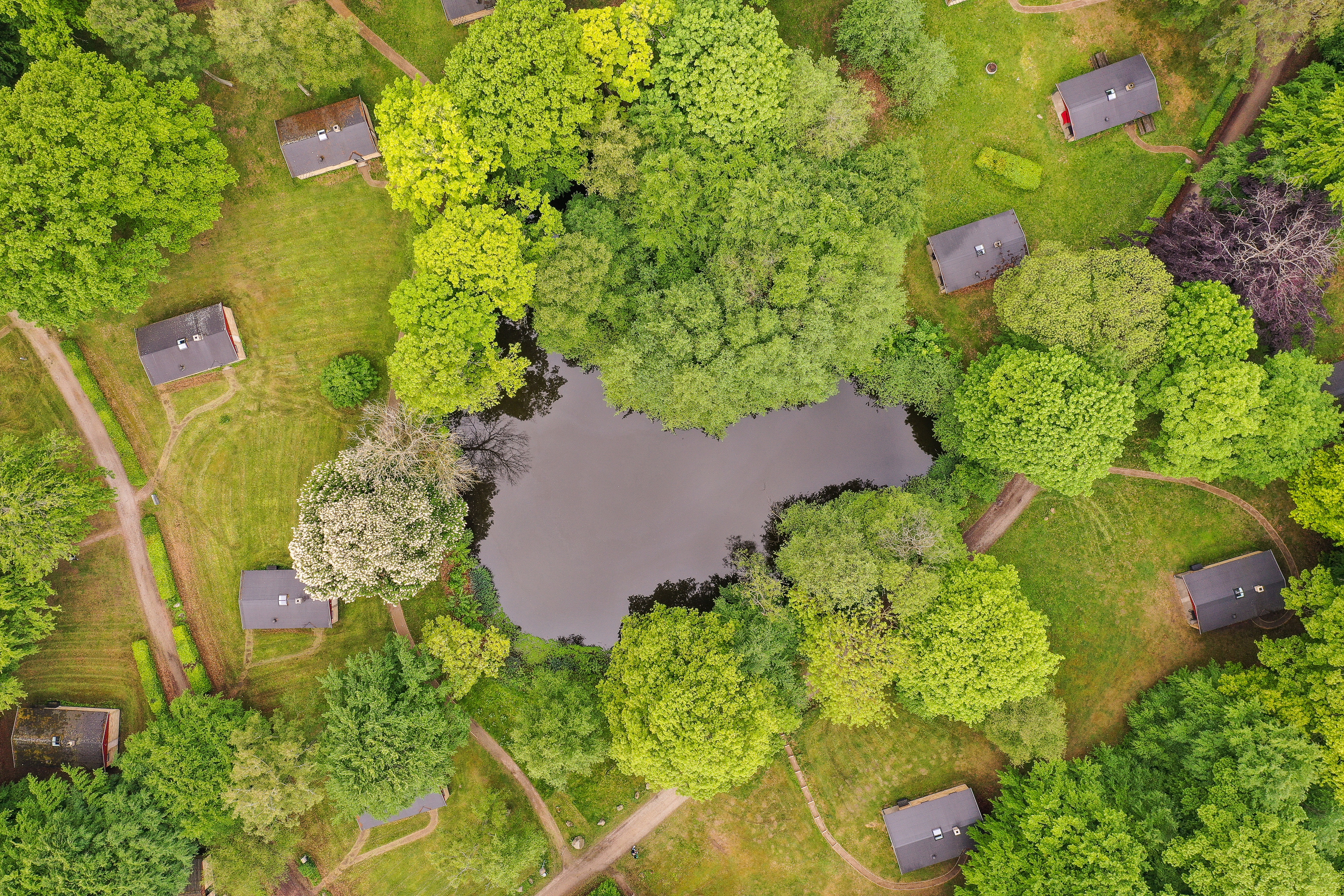 Luftfoto af Helsingør Ferieby: Ferieboligerne placeret i grønt område med stor sø i midten