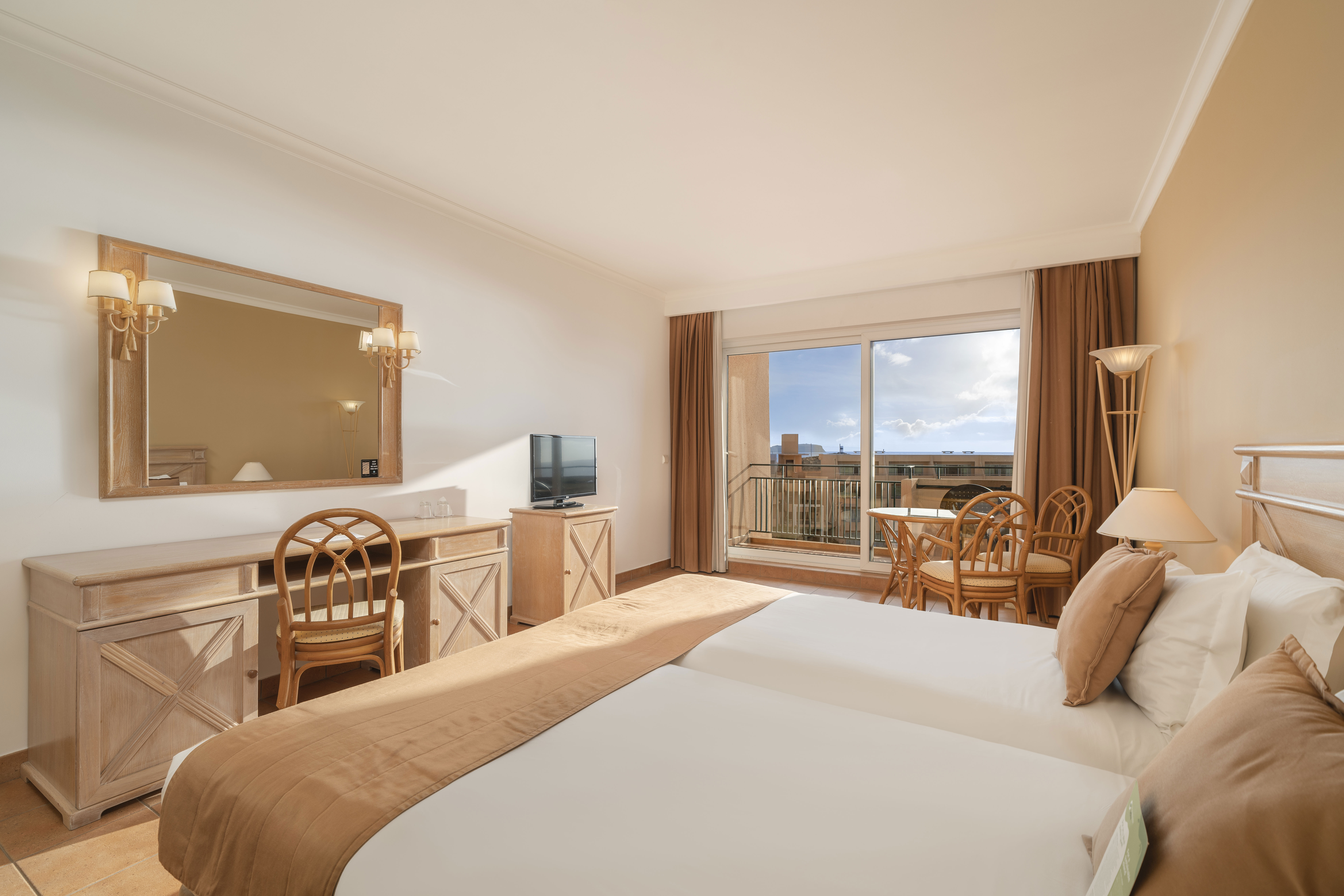 et beige i beige hotelværelse med stor seng i forgrunden