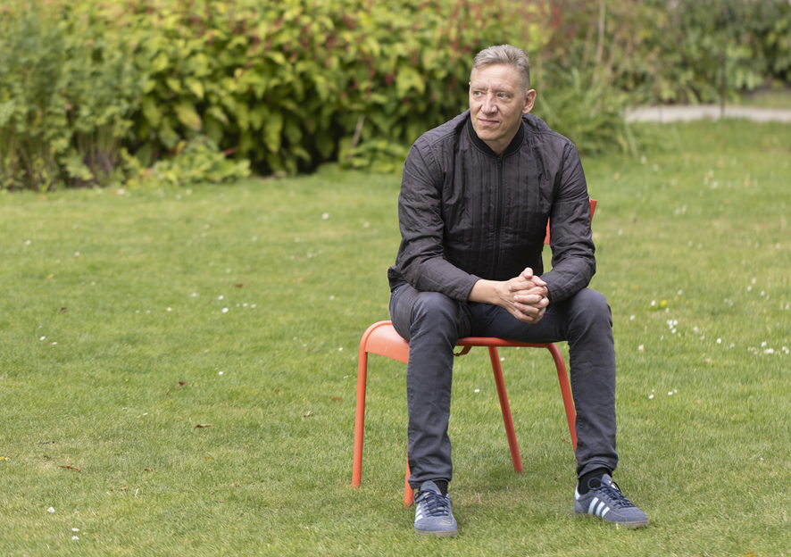 Christian Groes sidder på stol på græsplæne