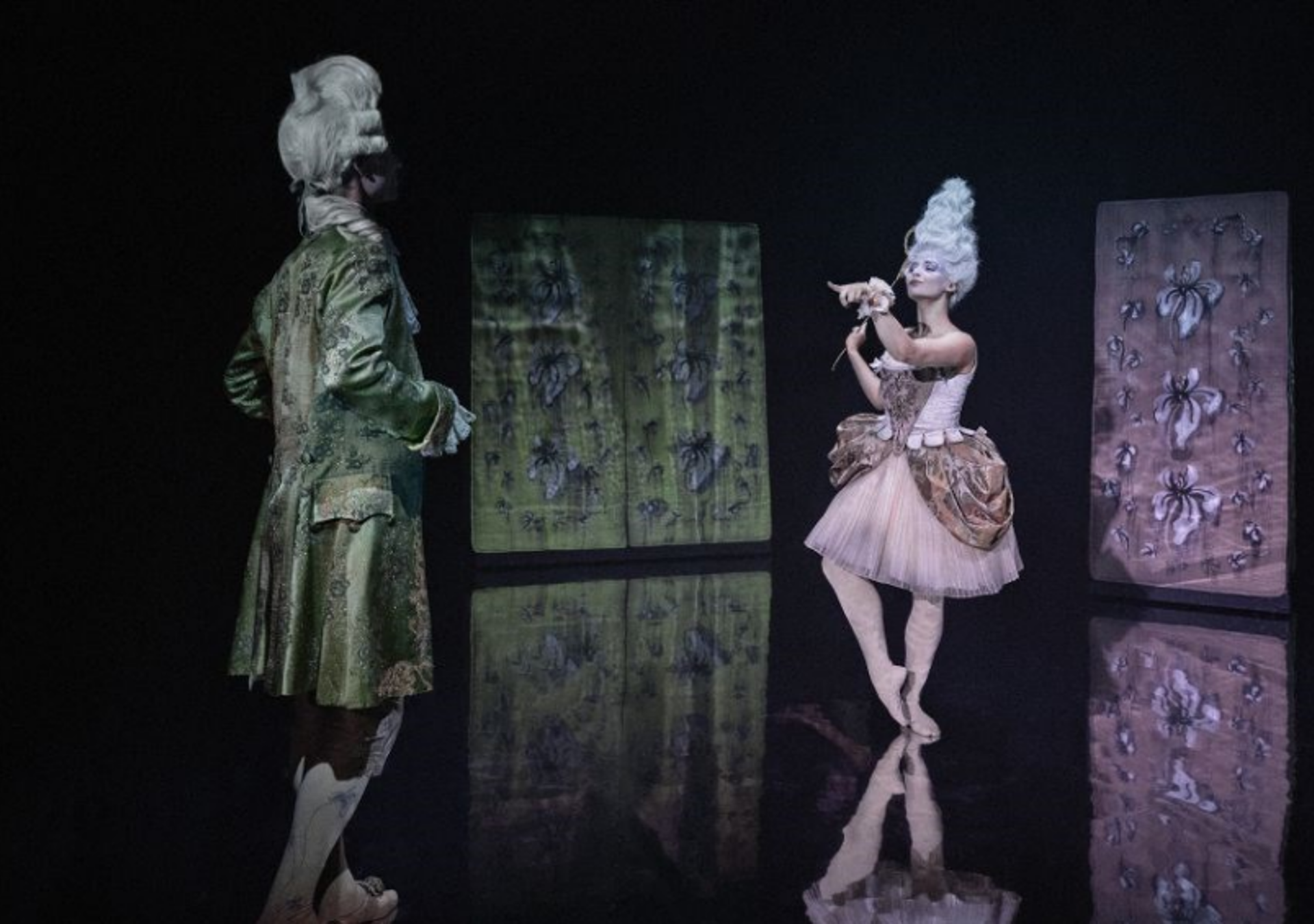 To balletdansere danser på mørk scene