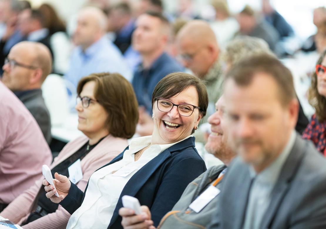 Adskillige mennesker samlet. Alle sidder på stole og vender ansigtet samme vej - måske mod en oplægsholder.